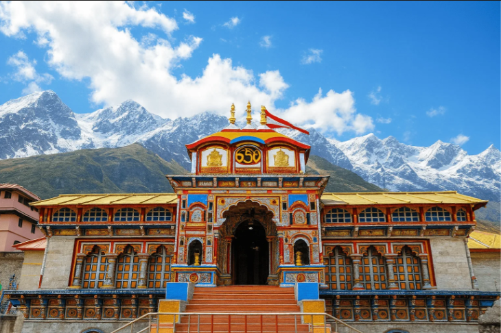Colorful facade of Badrinath Temple against the backdrop of snow-covered peaks.