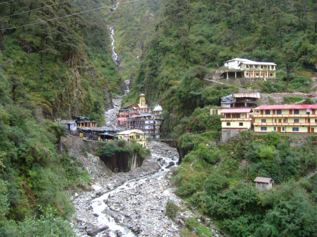 Yamunotri Temple surrounded by mountains and a flowing river in Uttarakhand.